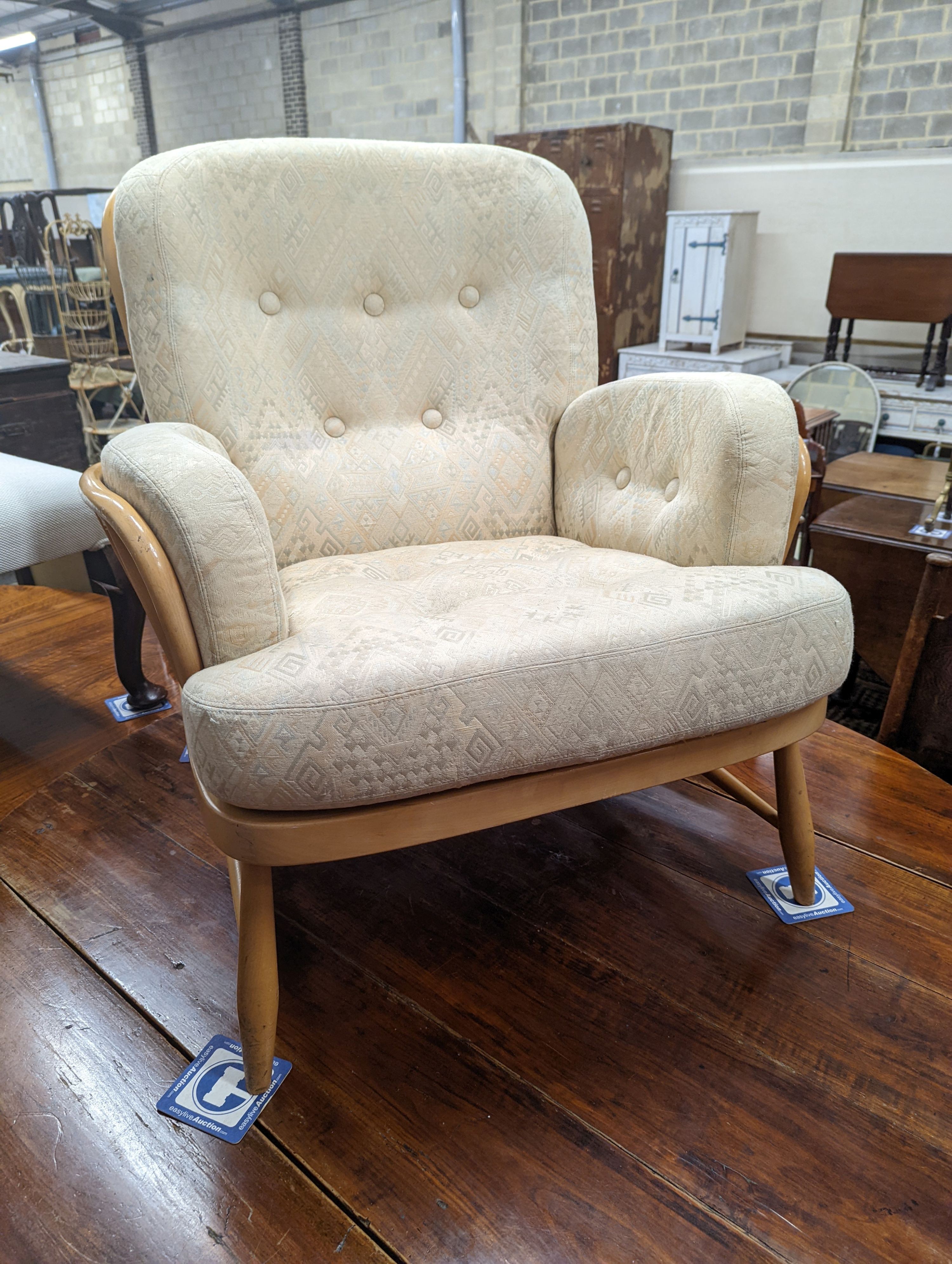 An Ercol Jubilee beech armchair with loose cushion upholstery, width 77cm, depth 80cm, height 86cm